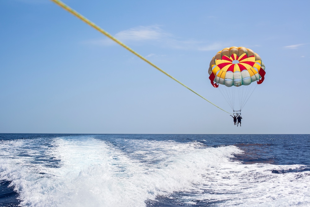 Two people parasailing over the ocean.