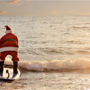santa clause on beach surfing