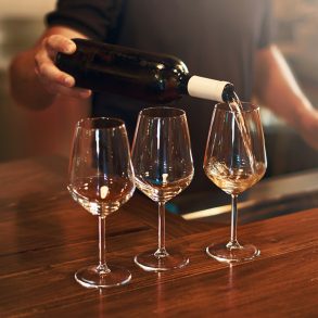 three glasses of wine being poured