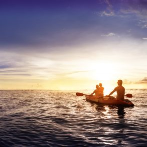 Family kayaking at sunrise