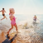 children running into ocean beach