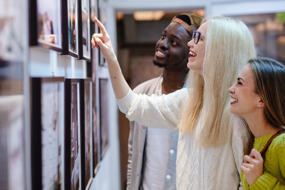 3 friends looking at art together.