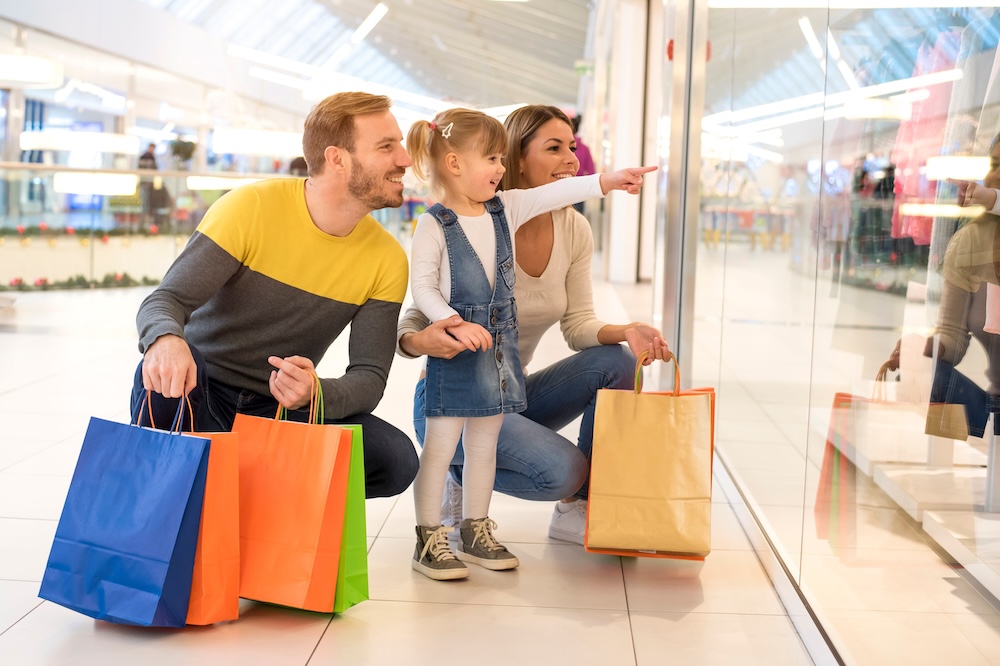 Happy family with child and shopping bags doing shopping.