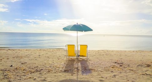 Two beach chairs on the sand.