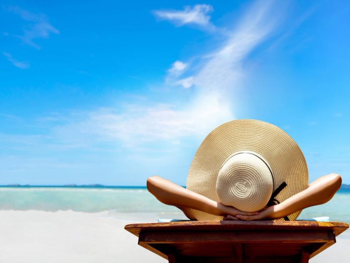 midweek stays on the outer banks, woman relaxing on beach