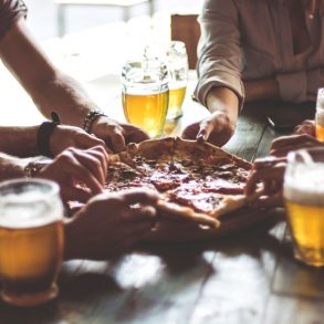 group spending time at an Outer Banks brewery enjoying beer and pizza