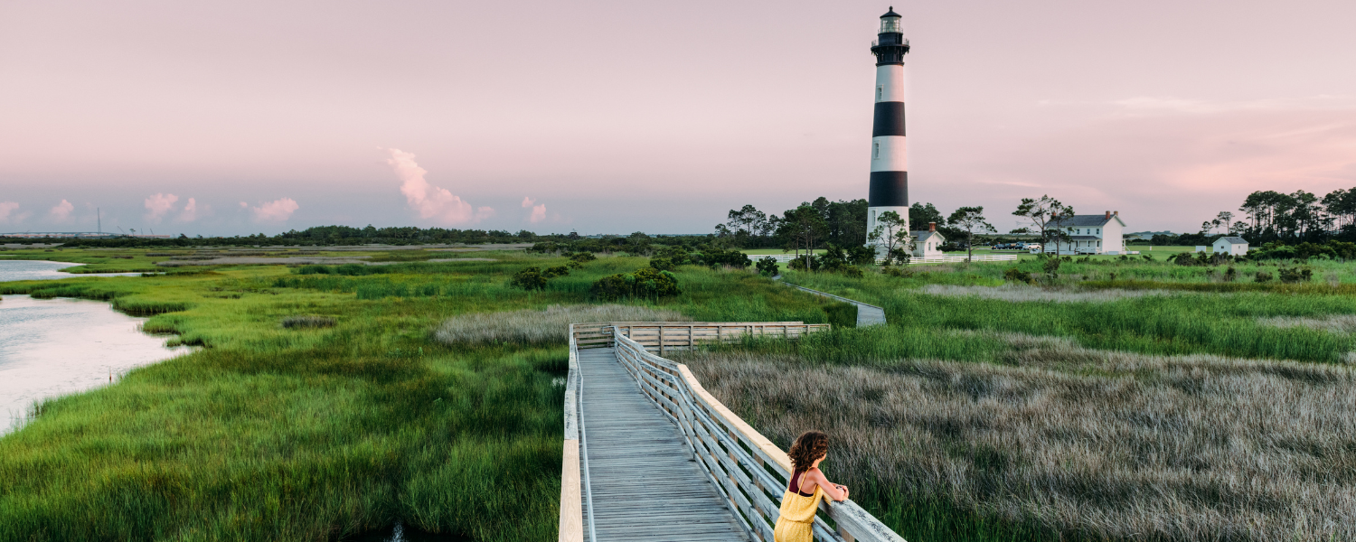 girl standing on boardwalk at bodie island lighthouse