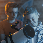 two boys looking through telescope