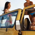 three people in jeep on beach