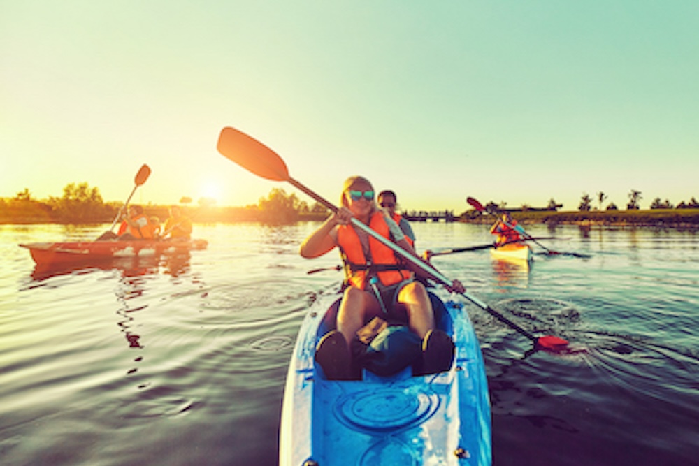 group kayaking through calm water