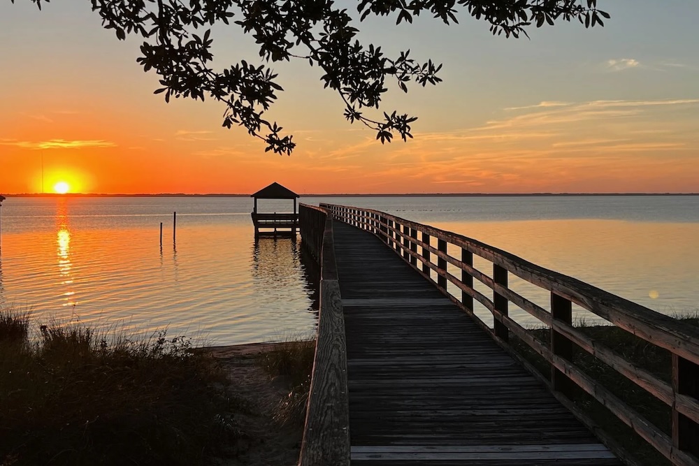 view of dock of Outer Banks home at sunset 