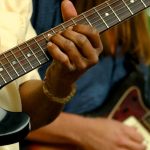 Close up of two people playing guitars