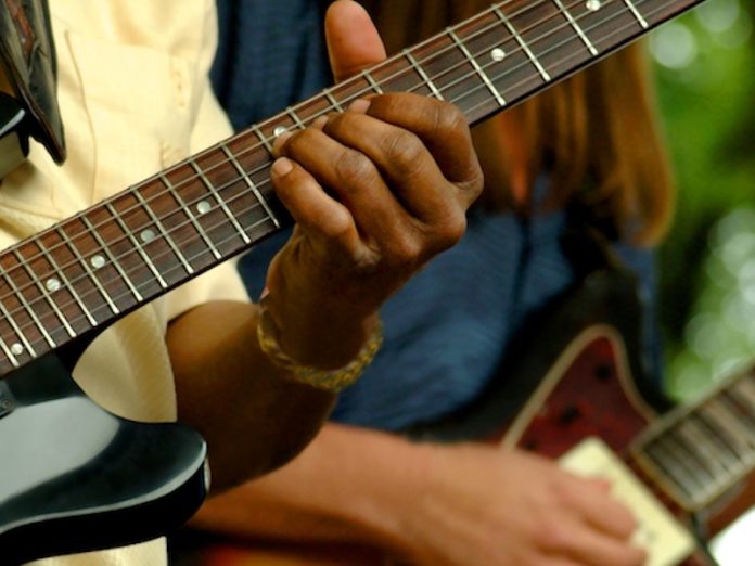 Close up of two people playing guitars