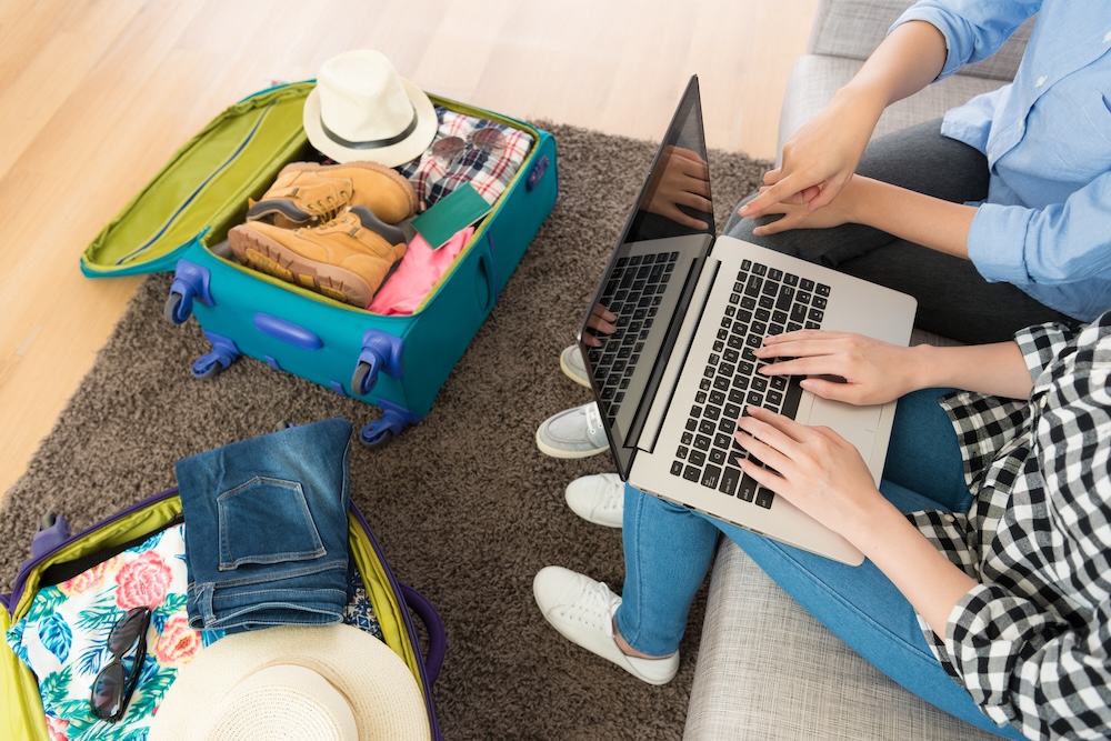 aerial view of couple looking on laptop as they plan a vacation