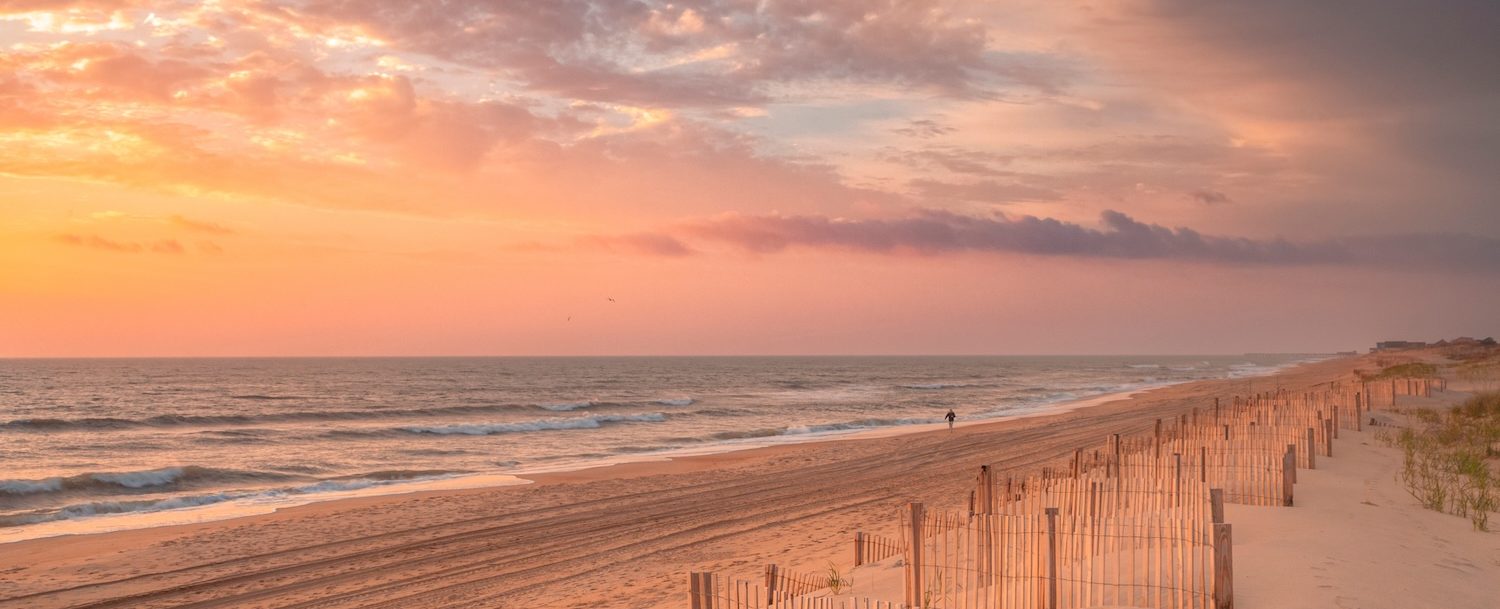 Lone individual going for an early morning walk at sunrise along the Outer Banks of North Carolina near Nags Head