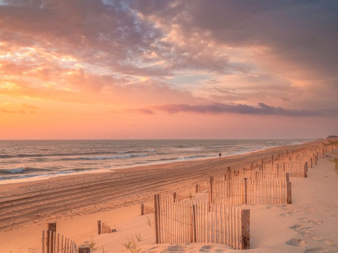 Lone individual going for an early morning walk at sunrise along the Outer Banks of North Carolina near Nags Head