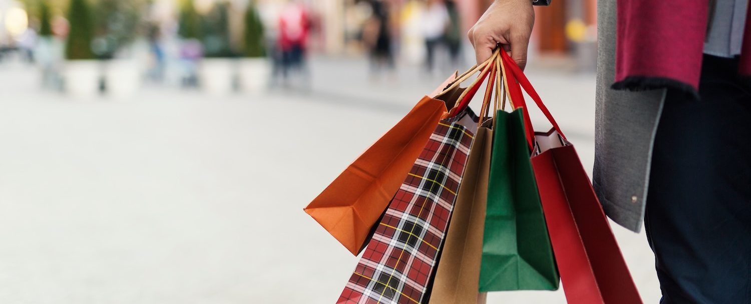 A person holding holiday shopping bags.