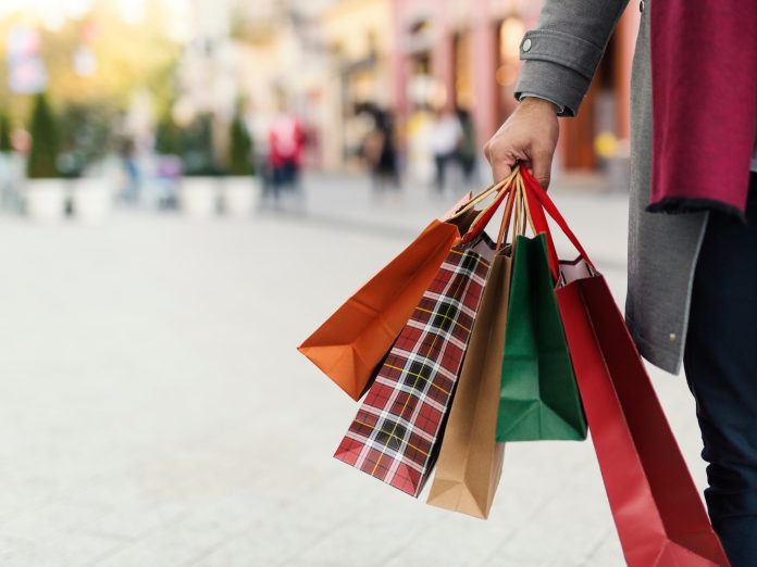 A person holding holiday shopping bags.